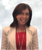 Smiling woman wearing a beige blazer and red top.