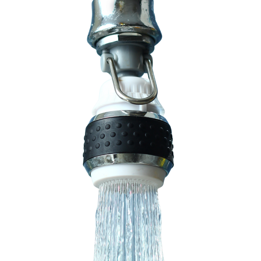 Close-up of a metal faucet spray head with a black textured grip, water spraying down from it.